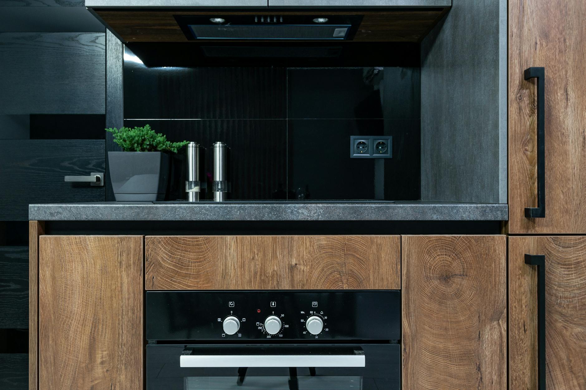Cuisine en bois et pierre avec touches de laiton, tendance déco matières naturelles