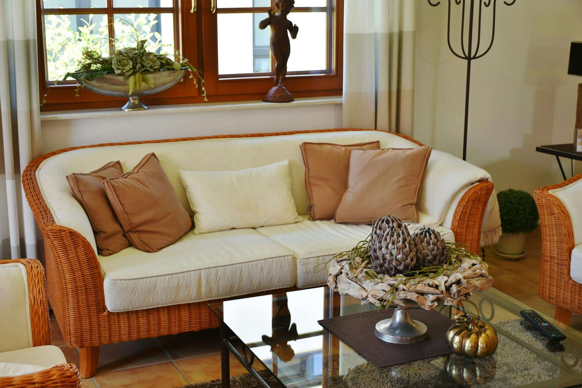 Idées déco salon : canapé en rotin et coussins terracotta dans un séjour chaleureux